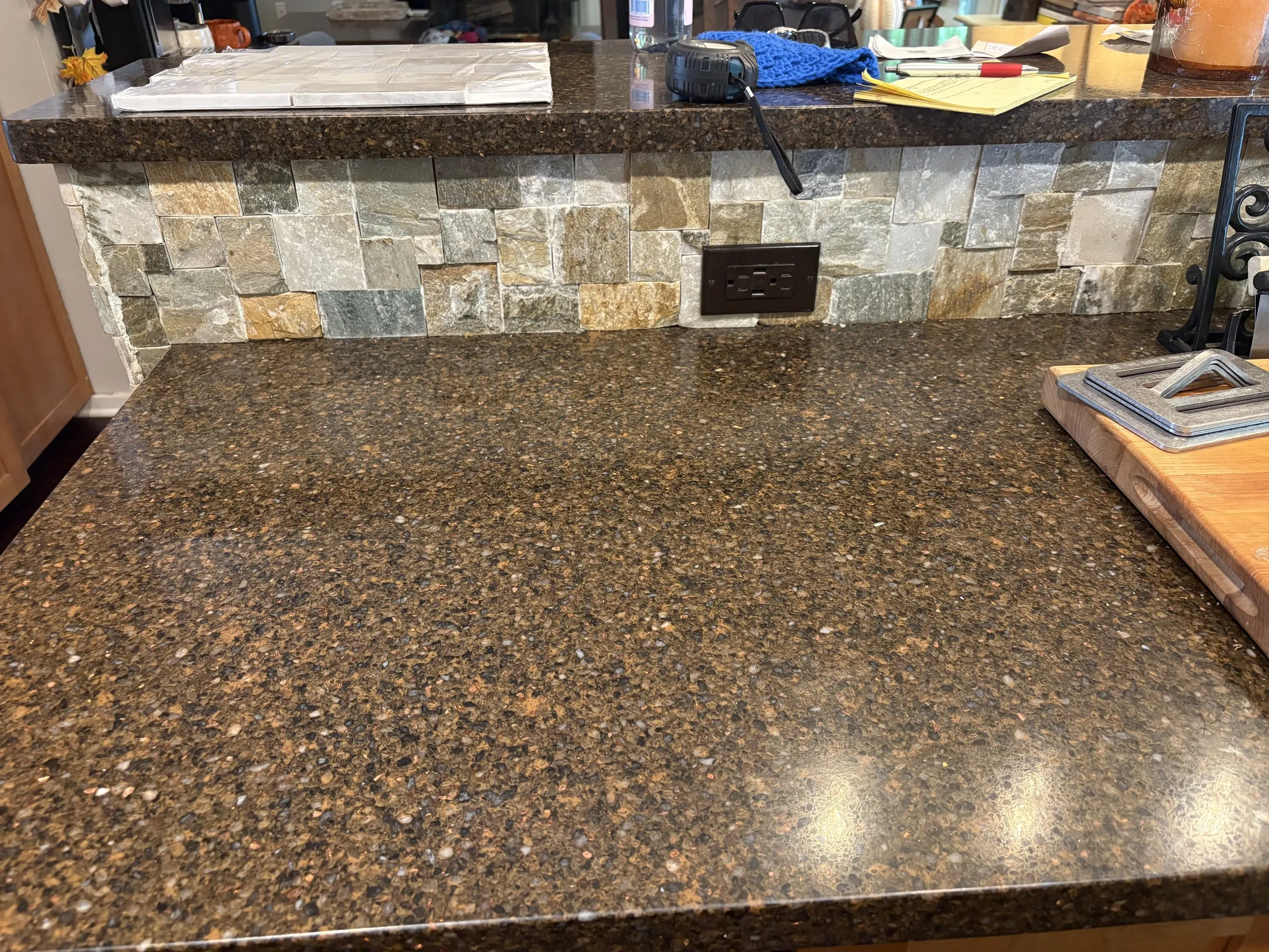 Kitchen countertop transition and natural-stone facing detail with electrical outlet