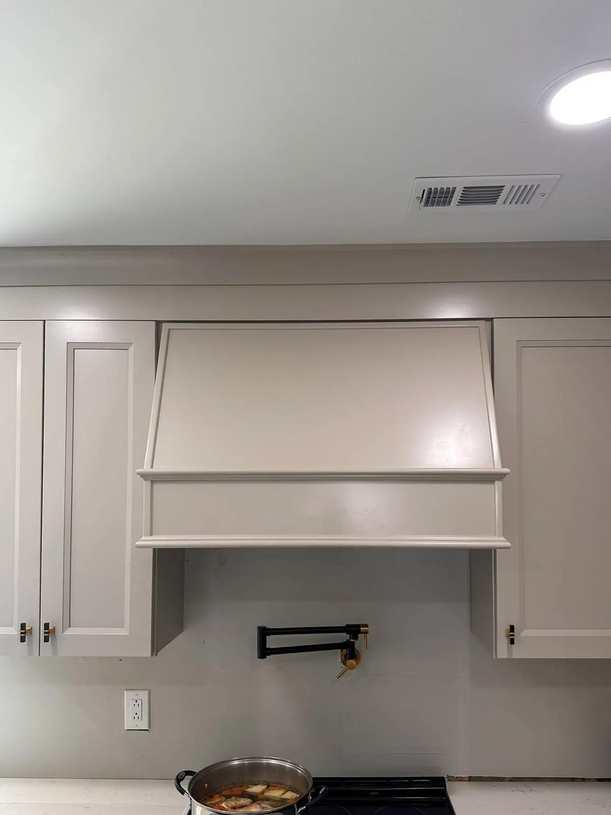 Kitchen remodel range wall with custom hood cabinet and upper cabinetry
