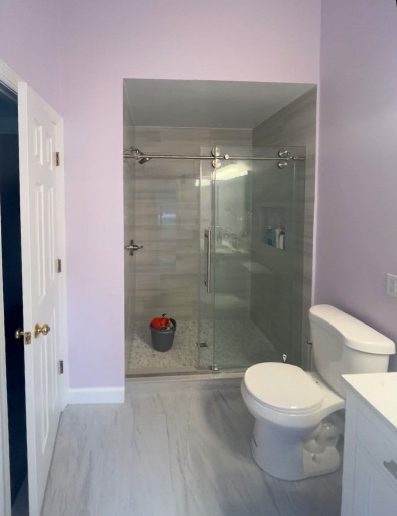 Bathroom remodel with glass shower and gray tile surround
