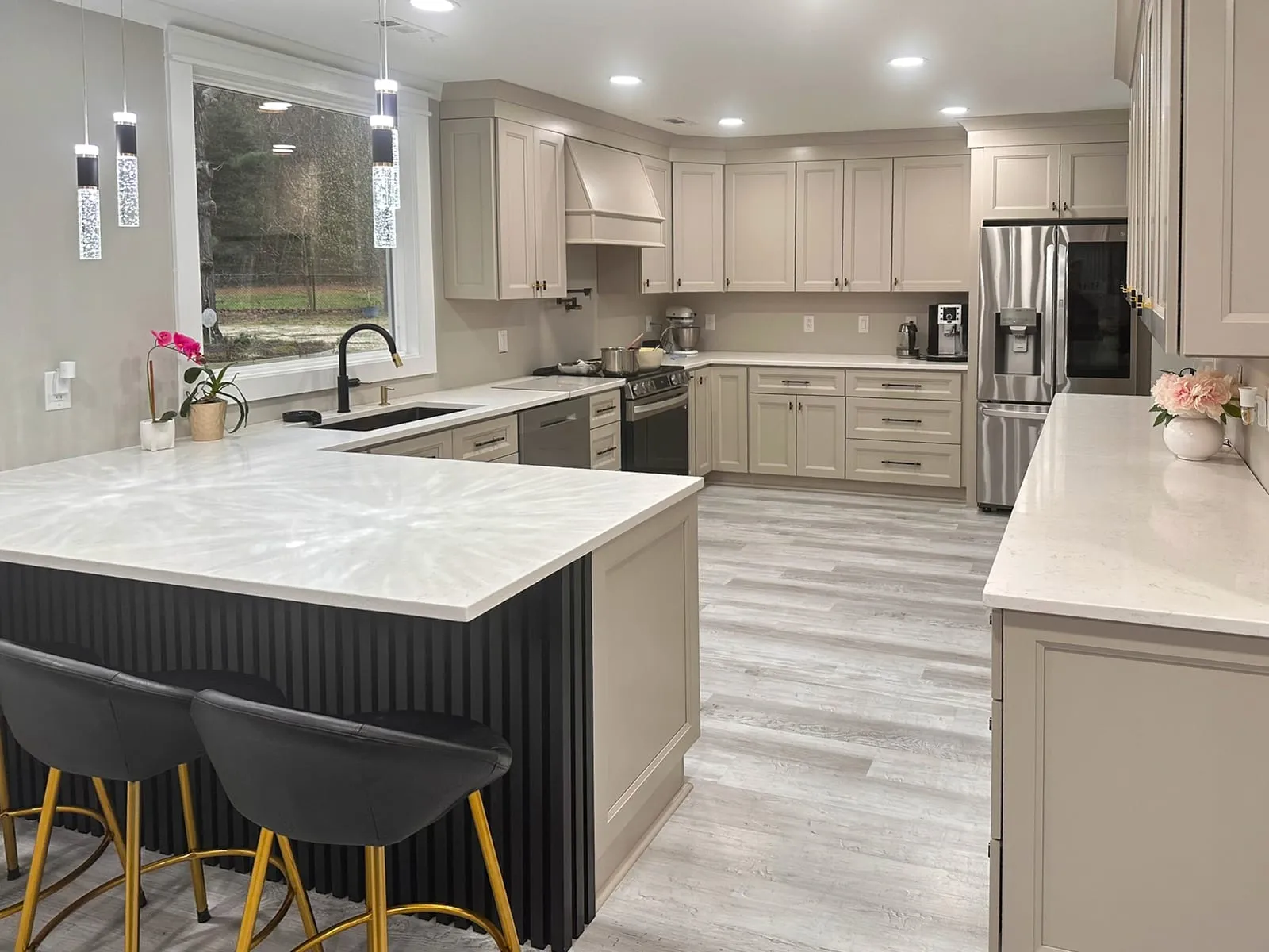 Kitchen remodel with island seating, pendant lights, gray cabinets, and wide counter runs