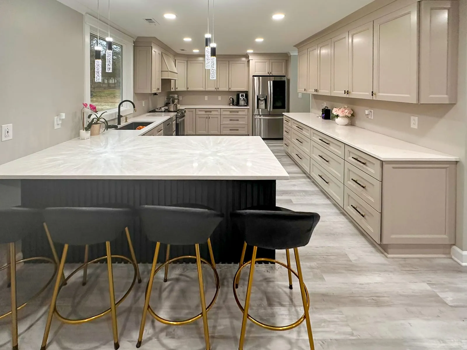 Open kitchen remodel with gray cabinetry, long cabinet run, and light wood flooring