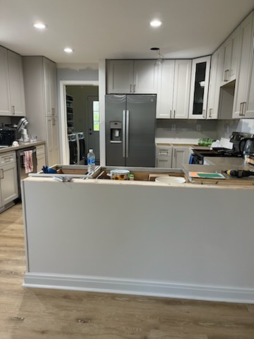Kitchen peninsula with gray cabinet base and remodel materials during finishing