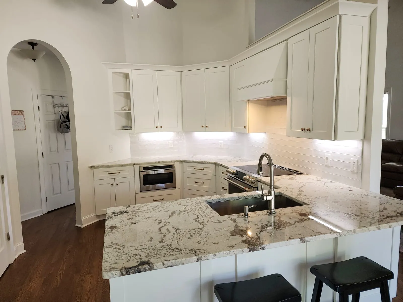 Kitchen remodel with white cabinets, quartz countertops, sink, and tile backsplash