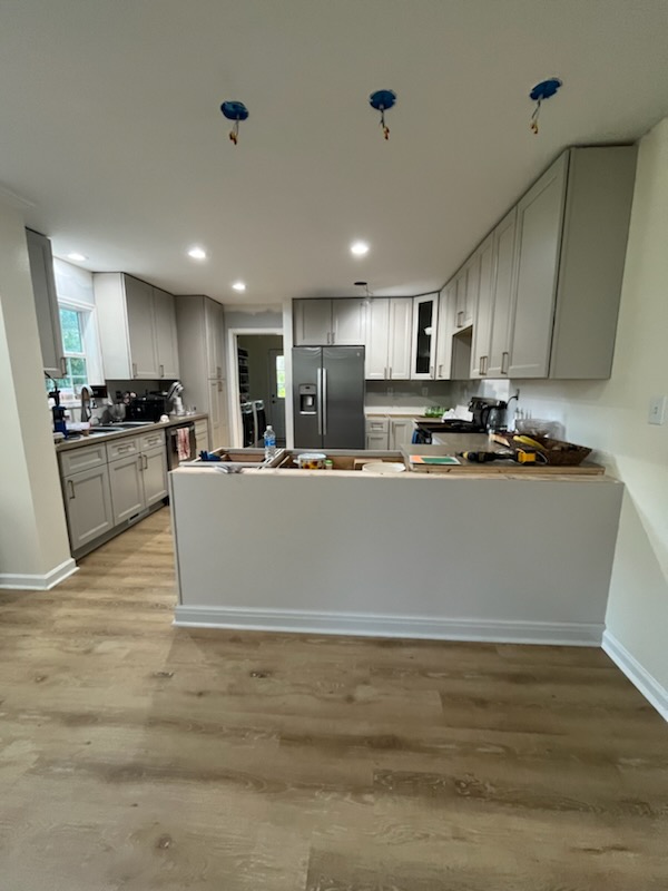 Kitchen remodel with recessed lighting, gray cabinets, and peninsula base
