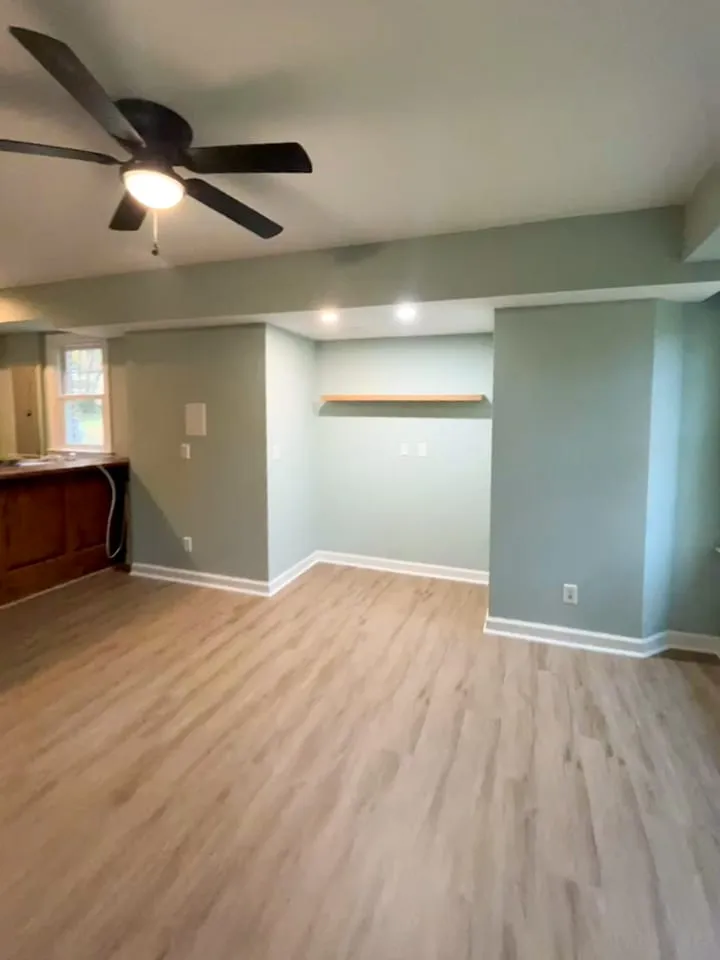 Living room remodel with recessed wall niche, updated flooring, and bar area