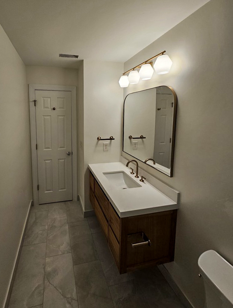 Bathroom remodel with single vanity and arch mirror