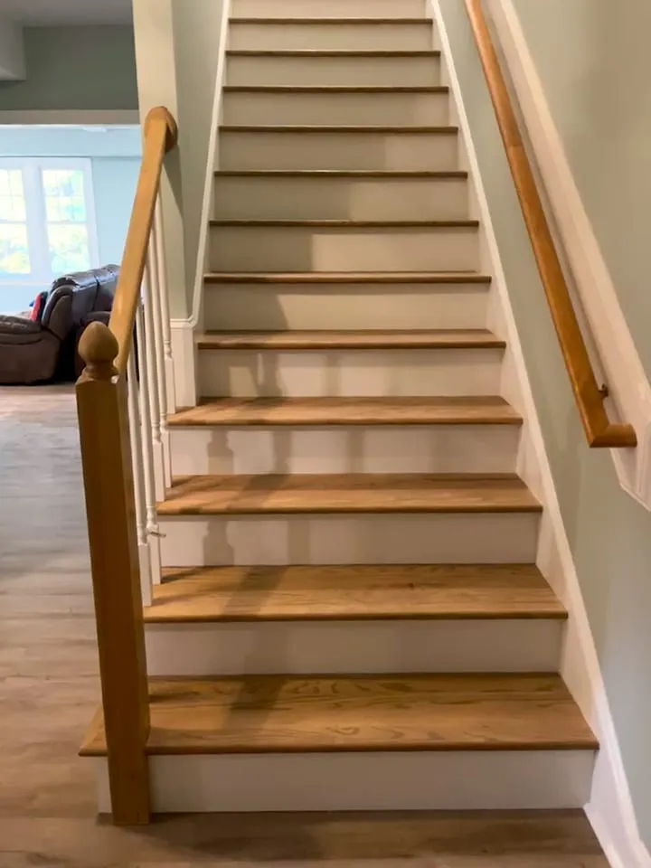 Close view of staircase remodel with wood treads and white risers