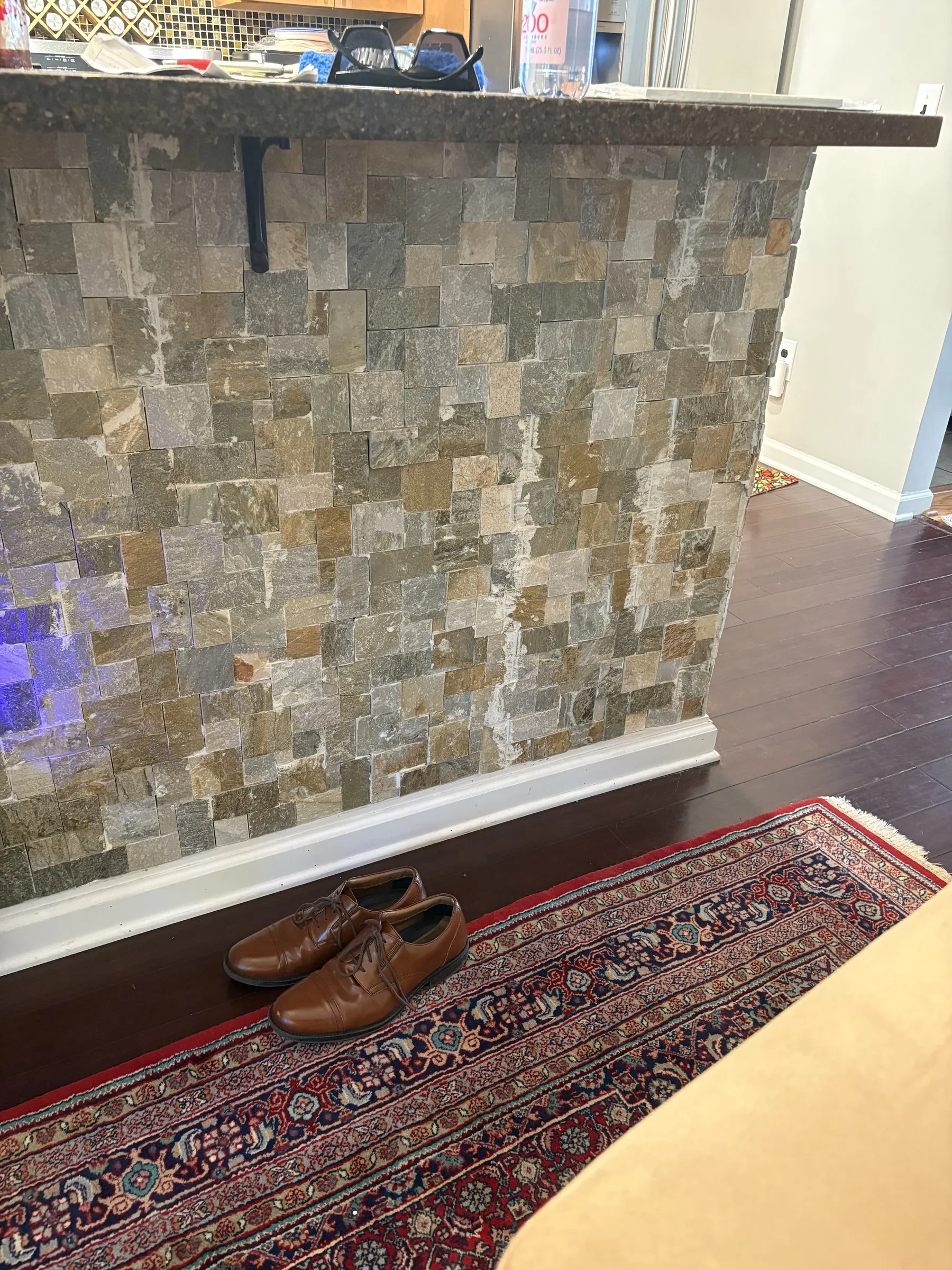 Kitchen peninsula during natural-stone tile facing installation