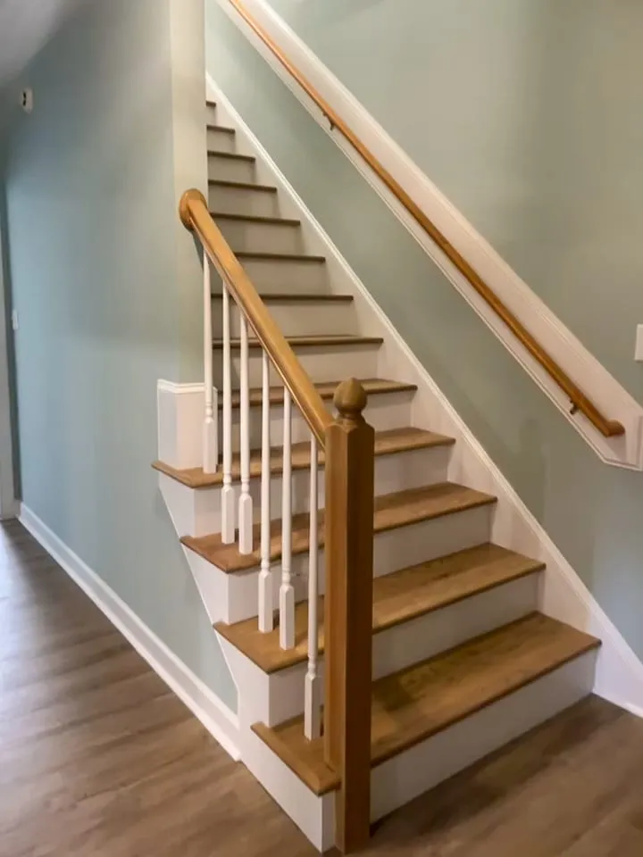 Staircase remodel with wood treads, white risers, and updated railings